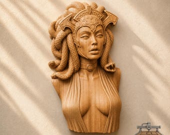May include: A light brown wooden wall sculpture depicting a bust of Medusa with snakes for hair, wearing an ornate headpiece and a choker necklace. The figure has detailed facial features and a textured garment. The text CNC ROUTER IDEAS is visible.