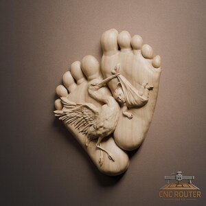 May include: A wooden carving featuring two large footprints with a stork carrying a baby in a cloth. The stork is intricately detailed, with outstretched wings and a long beak. The baby is wrapped in a cloth. The carving is set against a brown background.