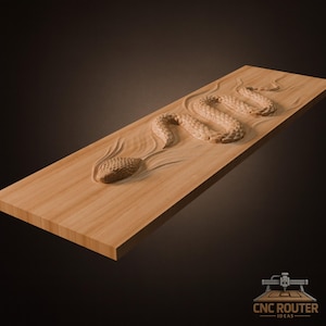 May include: A wooden rectangular plaque with a carved relief of a snake. The snake is depicted in a winding pose, with detailed scales and a textured head. The wood has a light brown color and the carving is set against a smooth background.
