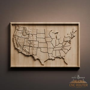 May include: A wooden relief map of the United States, showcasing each state with detailed borders and topographical features. The map is framed in a light-colored wood, creating a natural and rustic aesthetic. The CNC Router Ideas logo is in the bottom right corner.