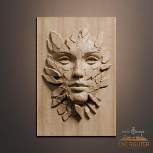 May include: A wooden relief carving of a woman's face, partially obscured by fragmented, leaf-like shapes. The artwork is mounted on a rectangular wooden panel, showcasing detailed textures and shadows. The piece is likely a decorative wall hanging.