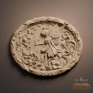 Op de afbeelding: Houten reliëfsnijwerk van een fee in een bloemenomgeving. De fee heeft grote vleugels en is omringd door bloemen en vlinders. Het snijwerk is ovaal van vorm met een gedetailleerde rand. Het hout heeft een natuurlijke, lichtbruine kleur.