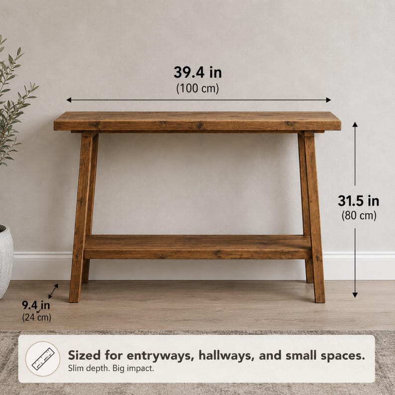 May include: A brown wooden console table with a rectangular top and a lower shelf. The table measures 100 cm wide, 80 cm high, and 24 cm deep. Text on the image states: Sized for entryways, hallways, and small spaces. Slim depth. Big impact.