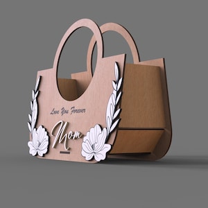 May include: A wooden decorative handbag with two handles. The front features the word "Mom" in cursive, with "Love You Forever" above it. Floral and leaf designs are on the front. The bag is made of light brown wood.
