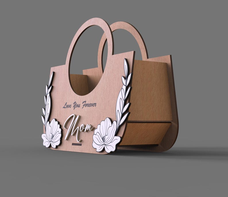 May include: A wooden decorative handbag with two handles. The front features the word "Mom" in cursive, with "Love You Forever" above it. Floral and leaf designs are on the front. The bag is made of light brown wood.