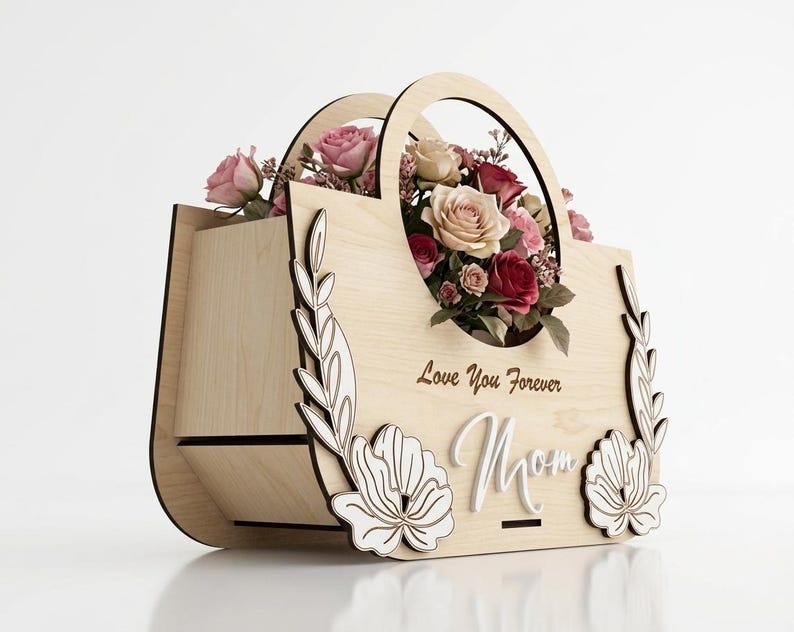 May include: A wooden flower basket with a handle, filled with pink and red roses. The basket is decorated with floral cutouts and the words "Love You Forever Mom".