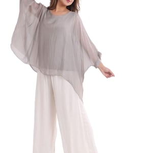 May include: A light gray, sheer, batwing-style top paired with wide-leg, off-white pants. The top has a rounded neckline and three-quarter sleeves. The pants are loose-fitting and flowy. The outfit is suitable for casual or semi-formal wear.