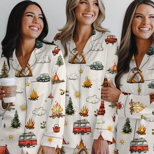 以下が含まれることがあります： クリーム色のパジャマセット。キャンプをテーマにしたパターンで、キャンプファイヤー、テント、ヴィンテージカー、木、赤いキャンピングカーのイラストが含まれています。パジャマはボタンダウンシャツとマッチングパンツです。