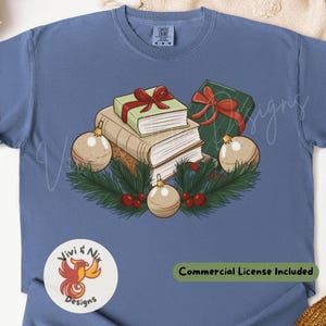 May include: Blue t-shirt with a festive graphic. The design includes books, wrapped gifts, baubles, and foliage. The text "Commercial License Included" is present.