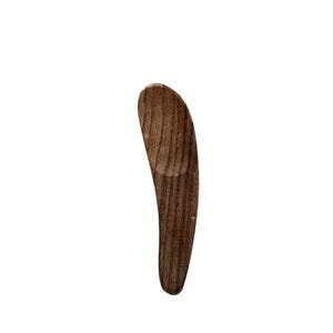 Puede incluir: Una cuchara pequeña de madera con un mango curvo y una pala redonda. La cuchara está hecha de madera oscura con un patrón de veta natural.