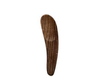 May include: A small, wooden spoon with a curved handle and a rounded scoop. The spoon is made of dark wood with a natural grain pattern.