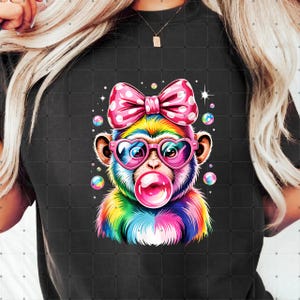 May include: A colorful graphic of a monkey blowing a bubblegum bubble. The monkey wears heart-shaped glasses and a pink polka dot bow. The monkey's fur is rainbow-colored, and the background is black.