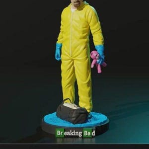 以下が含まれることがあります： テレビドラマ『ブレイキング・バッド』のウォルター・ホワイトの黄色いジャンプスーツ姿のフィギュア。フィギュアはピンクのぬいぐるみと黒いバッグを持っています。フィギュアは「ブレイキング・バッド」と書かれた青い台座の上に立っています。