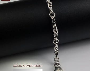 May include: A silver chain bracelet featuring elongated, polished links connected by circular rings, ending in a large, functional lobster claw clasp. The text on the image indicates the item is solid silver and weighs 18.9g, with reference number 6.