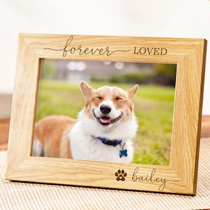 Könnte beinhalten: Holzbilderrahmen mit einem Foto eines lächelnden Corgi-Hundes. Der Rahmen trägt die Aufschrift "forever loved" und "bailey" mit einem Pfotenabdruck. Der Hund trägt ein blaues Halsband und einen Anhänger.