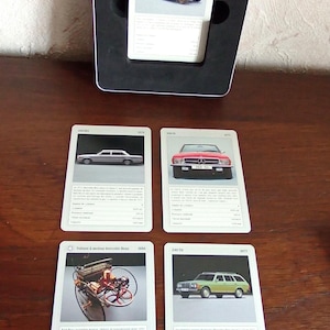 Może przedstawiać: Kolekcja kart z zabytkowymi samochodami, w tym Benz 10/30 h, sedan, czerwony kabriolet, Benz z silnikiem i zielone kombi. Karty są prezentowane w czarnej ramce.