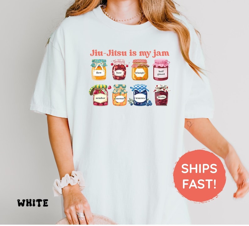 K&ouml;nnte beinhalten: Ein wei&szlig;es T-Shirt mit einer Grafik von acht bunten Gl&auml;sern, die mit verschiedenen Fr&uuml;chten und Beeren gef&uuml;llt sind. Jedes Glas ist mit Text beschriftet, darunter flow, base, triangle, half guard, armbar, mount, kimura und frame. Der Text Jiu-Jitsu is my jam ist in Rot &uuml;ber den Gl&auml;sern gedruckt.