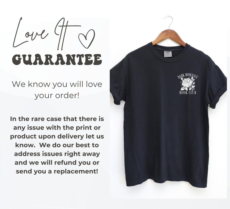 May include: A black short-sleeve t-shirt hanging on a wooden hanger. The shirt features a white graphic on the left chest area depicting a rose with the text "DARK ROMANCE BOOK CLUB" arched above and below the flower in a serif font.