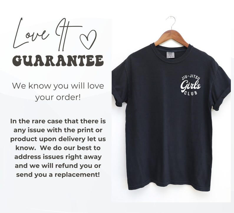Może przedstawiać: Czarny t-shirt z białym napisem "Jiu-Jitsu Girls Club" z przodu. Koszulka wisi na drewnianym wieszaku. Tekst po lewej stronie obrazu brzmi "Love It Guarantee" i "We know you will love your order!"