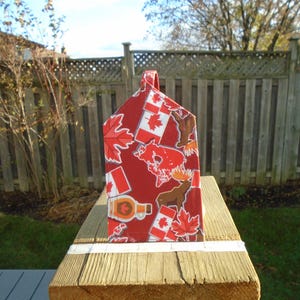 May include: A white ceramic mug with a black handle and the text "But First, Coffee" in a bold, black font. The mug is on a wooden surface. The mug is approximately 10 cm tall.