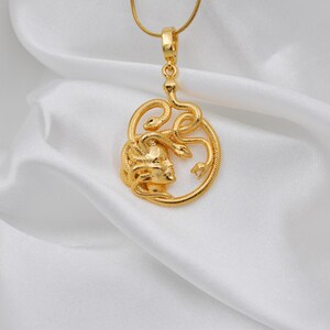 Close-up view of a handmade 18K gold plated Medusa pendant showing the intricate snake details. A protective Greek mythology necklace, unique spiritual gift for her, available in matte gold and silver finishes.