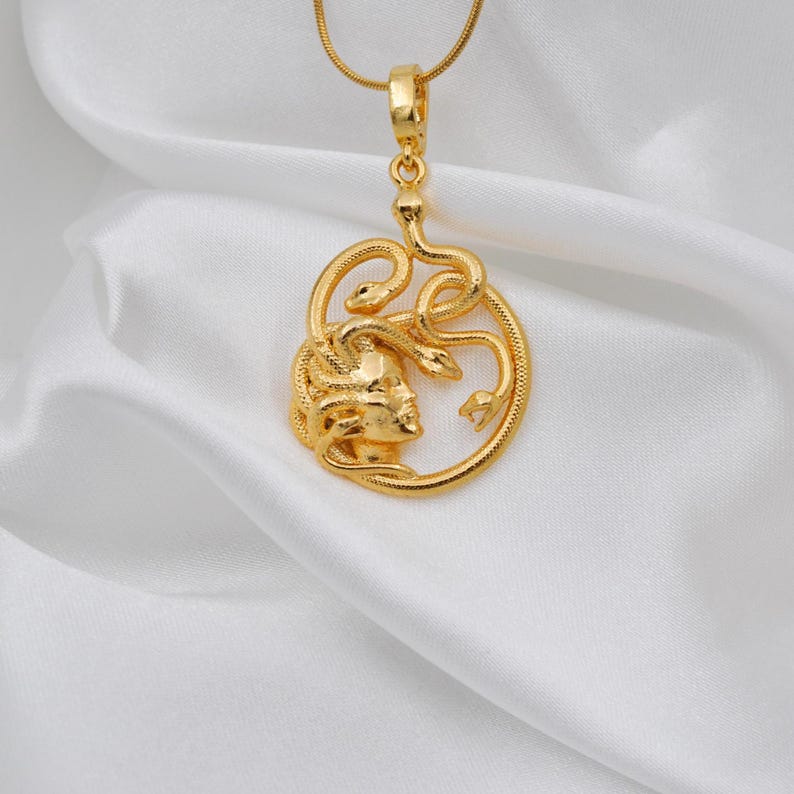 Close-up view of a handmade 18K gold plated Medusa pendant showing the intricate snake details. A protective Greek mythology necklace, unique spiritual gift for her, available in matte gold and silver finishes.
