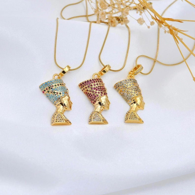 Handmade 24K gold plated Nefertiti necklaces shown in three vibrant gemstone colors including turquoise fuchsia and clear. This collection of Egyptian queen jewelry for women serves as a stunning anniversary gift for her or a high quality spiritual gift for mom designed for daily elegance.