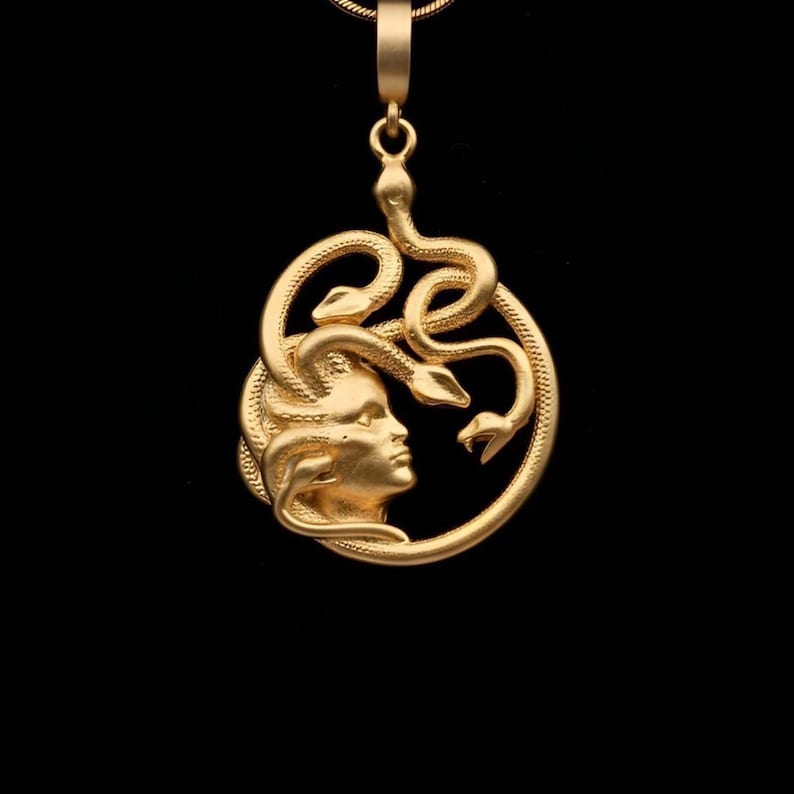 Handmade 18K gold plated Medusa necklace featuring a circular pendant with a detailed relief of Medusa's head and serpents. Available in matte gold, shiny gold, and antique silver finishes. Ancient Greek mythology jewelry, protective snake pendant, unique spiritual gift for her, versatile mythological necklace for everyday wear.