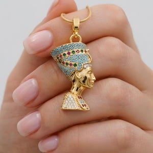 Handmade 24K gold plated Nefertiti necklace adorned with vibrant turquoise red and green gemstones. This intricate Egyptian queen jewelry for women serves as a stunning anniversary gift for her. A high quality spiritual necklace for mom handcrafted for daily elegance and protection.