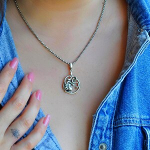 A woman wearing the Medusa snake necklace to show the scale and elegant fit. Personalized mythological jewelry, anniversary gift for her, 18K gold plated spiritual protector pendant in boho style.