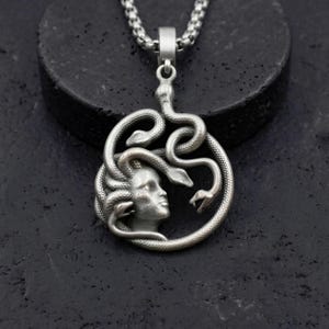 Handmade 18K gold plated Medusa necklace featuring a circular pendant with a detailed relief of Medusa's head and serpents. Available in matte gold, shiny gold, and antique silver finishes. Ancient Greek mythology jewelry, protective snake pendant, unique spiritual gift for her, versatile mythological necklace for everyday wear.