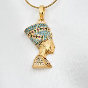 Handmade 24K gold plated Nefertiti necklace adorned with vibrant turquoise red and green gemstones. This intricate Egyptian queen jewelry for women serves as a stunning anniversary gift for her. A high quality spiritual necklace for mom handcrafted for daily elegance and protection.
