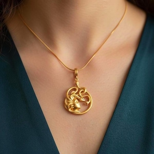 A woman wearing the Medusa snake necklace to show the scale and elegant fit. Personalized mythological jewelry, anniversary gift for her, 18K gold plated spiritual protector pendant in boho style.