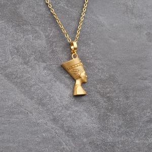 Handmade Nefertiti necklace available in both matte and shiny 24K gold plated finishes. Whether you select the polished or matte gold necklace for women it serves as a stunning anniversary gift for her. These ancient Egyptian necklaces are high quality gifts for mom handcrafted for those who love unique spiritual jewelry.
