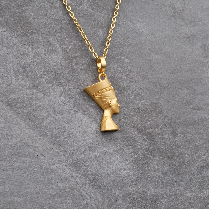 Handmade Nefertiti necklace available in both matte and shiny 24K gold plated finishes. Whether you select the polished or matte gold necklace for women it serves as a stunning anniversary gift for her. These ancient Egyptian necklaces are high quality gifts for mom handcrafted for those who love unique spiritual jewelry.