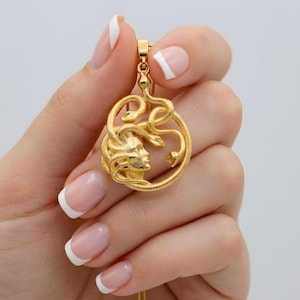 Close-up view of a handmade 18K gold plated Medusa pendant showing the intricate snake details. A protective Greek mythology necklace, unique spiritual gift for her, available in matte gold and silver finishes.