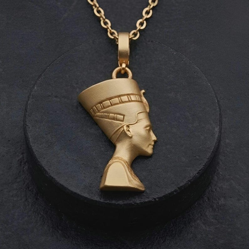 Handmade Nefertiti necklace available in both matte and shiny 24K gold plated finishes. Whether you select the polished or matte gold necklace for women it serves as a stunning anniversary gift for her. These ancient Egyptian necklaces are high quality gifts for mom handcrafted for those who love unique spiritual jewelry.