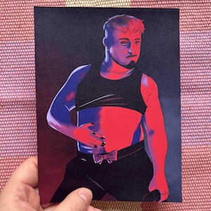 Puede incluir: Una impresión que presenta una ilustración estilizada de una persona con un top corto y pantalones negros, con una pajarita. La obra de arte utiliza una paleta de colores rojo, azul y negro, destacando el tono de piel de la persona.