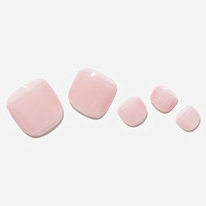 May include: Five light pink, square-shaped artificial toenails are arranged on a white background. The nails have a glossy finish and are of varying sizes, with the largest on the left and decreasing in size to the right.
