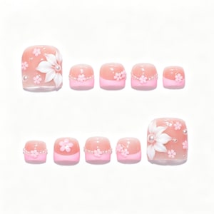 Könnte beinhalten: Ein Set aus zehn Zehennagel-Aufklebern mit einer zartrosa Basis und French-Tip-Design. Die größeren Nägel sind mit weißen 3D-Blüten und kleinen Perlen verziert, während die kleineren Nägel zarte rosa Blumenapplikationen aufweisen.