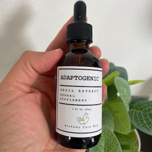 Può includere: Una bottiglia di vetro marrone con un contagocce nero e un'etichetta bianca che recita "Adaptogenic Basil Extract Herbal Supplement 2 Fl Oz (60ml) Alchemy Care Med".