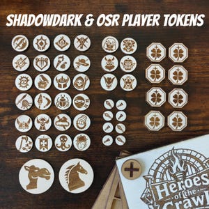 May include: A collection of light-colored wooden game tokens featuring various engraved icons, including character portraits, weapons, and symbols. The set includes circular and octagonal pieces, along with a wooden box labeled Heroes of the Crawl.