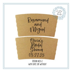 May include: Two brown cardboard coffee cup sleeves with black text. The top sleeve reads "Rosamund and Miguel." The bottom sleeve says "Olivia's Bridal Shower 05.27.23." The design is labeled "DESIGN N23-2 WITH DATE OR WITHOUT."