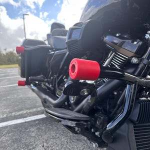 May include: A black motorcycle with red handlebar end caps that say "RADICAL SUPPLY CO."