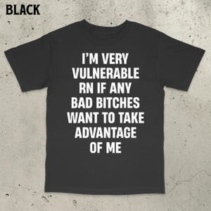 May include: Black t-shirt with white text: "I'M VERY VULNERABLE RN IF ANY BAD BITCHES WANT TO TAKE ADVANTAGE OF ME."
