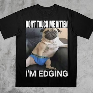 Könnte beinhalten: Schwarzes T-Shirt mit einer französischen Bulldogge, die blaue Unterwäsche trägt. Der Text "DON'T TOUCH ME KITTEN" steht über dem Bild und "I'M EDGING" darunter. Die Bulldogge sitzt auf einer schwarzen Oberfläche.
