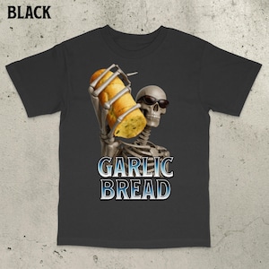 Könnte beinhalten: Schwarzes T-Shirt mit einem Skelett, das eine Sonnenbrille trägt und ein Knoblauchbrot hält. Die Worte "GARLIC BREAD" sind in einem blau-weißen Farbverlauf unter dem Skelett aufgedruckt.
