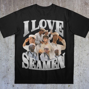 May include: Black t-shirt featuring a graphic design with the text "I LOVE SEAMEN" in a silver, distressed font. The design includes a collage of men in sailor uniforms saluting. The shirt is made of a soft material.