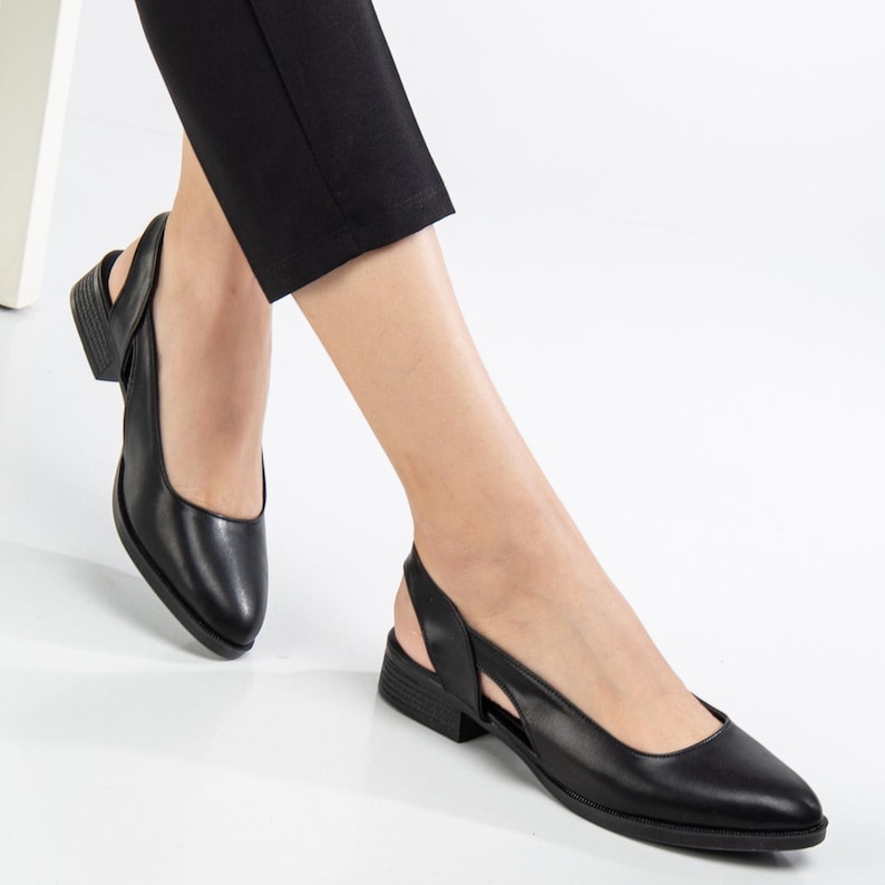 May include: A pair of black leather slingback shoes with a pointed toe and a low heel.