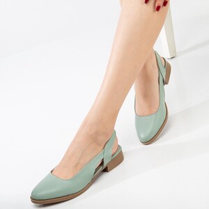 May include: A pair of light green leather slingback flats with a pointed toe and a low heel.